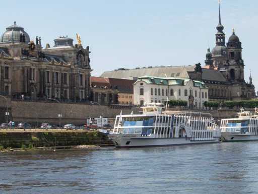 Zwei Motorschiffe liegen am Terrassenufer. Vom Heck eines Dampfers aus sieht man die Schiffe, die Silhouette der Stadt und ein kleines Stück der Augustusbrücke.