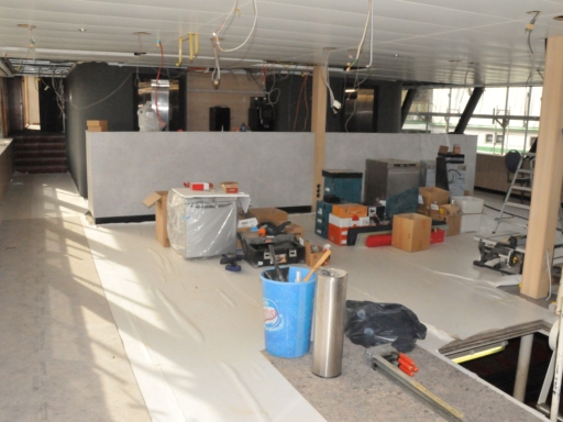 Conference Deck Bild vom Innenausbau des Motorschiffs Gräfin Cosel. Im künftigen Conference Deck sind die Deckenplatten schon eingesetzt. Kabel hängen herunter. Der neue Fußbocenn ist mit Planen geschätzt. Einrichtungsgegenstände und Werkzeug stehen im Raum.