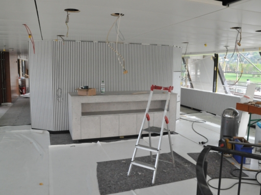 Fine Dining Club Innenausbau eines Motorschiffs auf der Werft in Laubegast. Erste Wandverkleidungen sind zu sehen, davor ein mobiler Tresen. Von der Decke hängen Kabel dort, wo sich künftig Lampen befinden werden. Der neue Fußboden ist mit Planen geschützt.