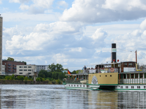 Dampfer fährt auf der Riesaer Elbe und im Hintergrund ist eine Fabrik.