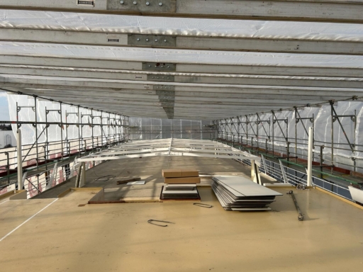 WhatsApp Image 2025-02-24 at 12.58.04 (1) Das Sonnendeck eines Salonschiffs, das auf der Werft steht und in ein Gerüst mit Planen eingehaust ist. Hier wurden alle Bänke und Tische demontiert.