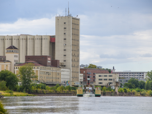Dampfer fährt auf der Elbe im Hintergrund ist eine Fabrik zu erkennen.
