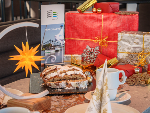 Weihnachtlich eingedeckter Tisch mit Stollen und Geschenken.